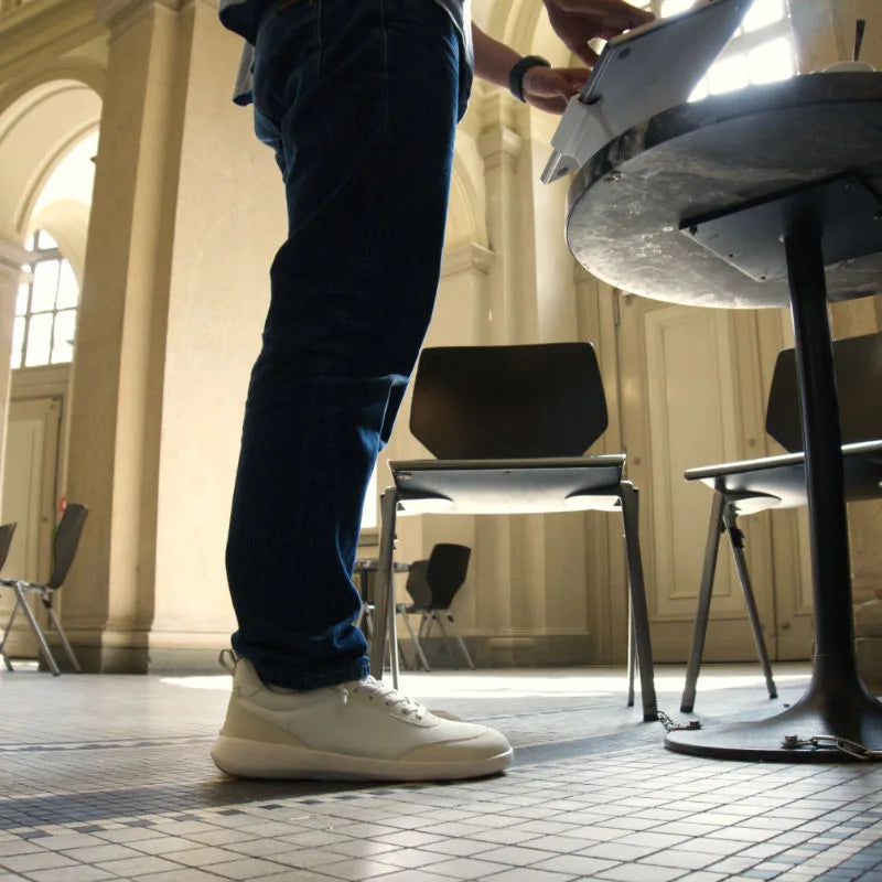 A person wearing off-white Footle sneakers during an ordinary indoor day